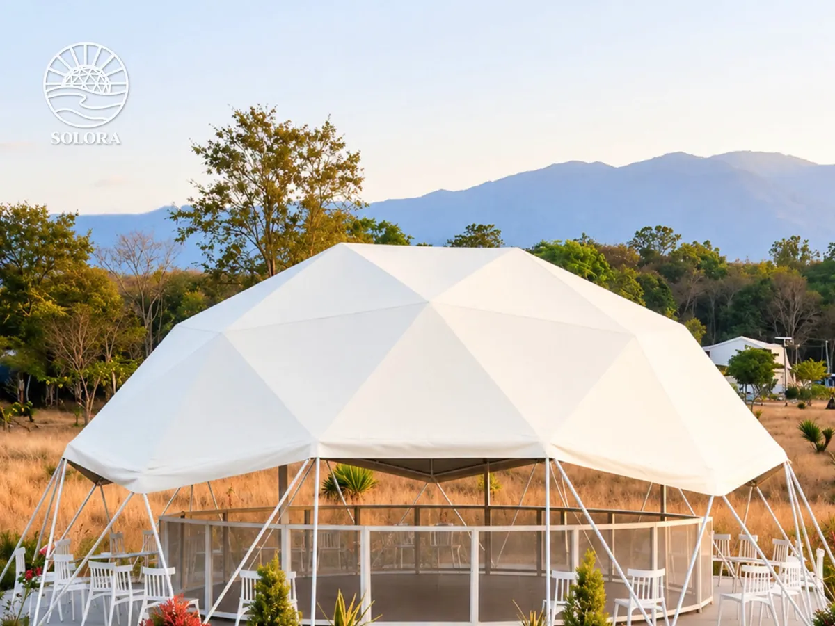 A Solora event dome pavilion set with seating, framed by mountains